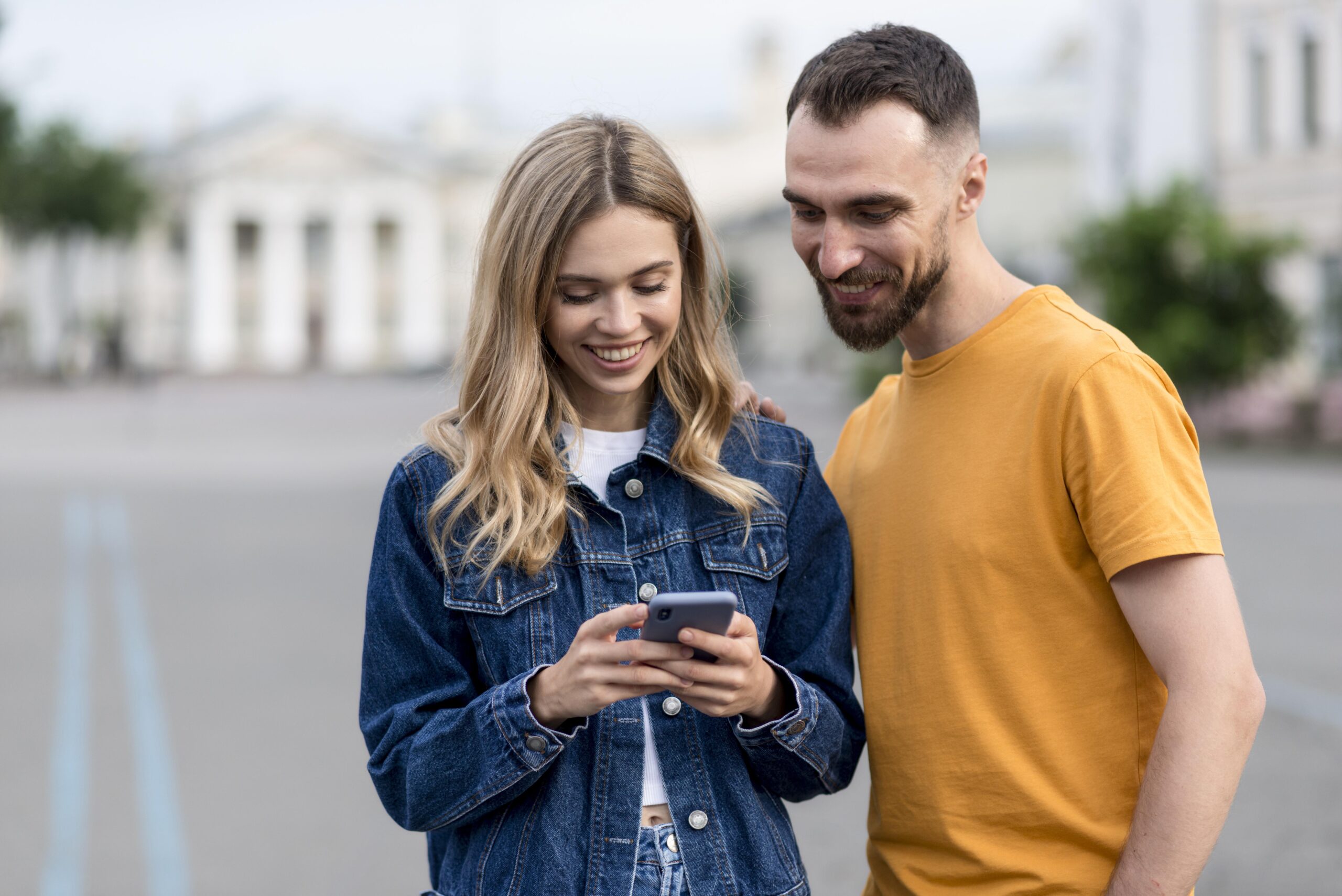 cute-young-couple-using-their-mobile-phone